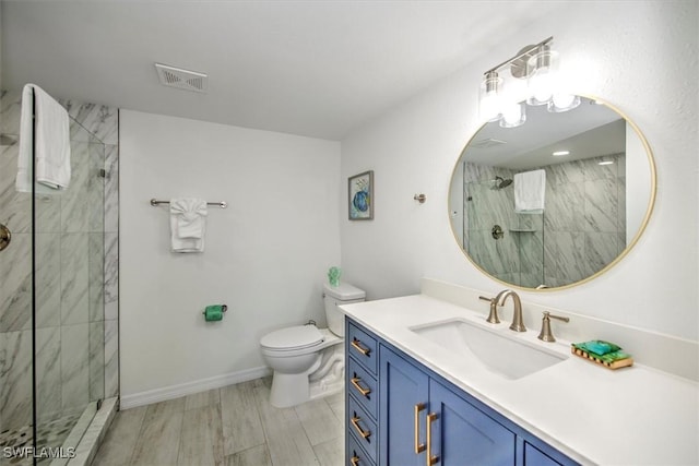 bathroom featuring vanity, toilet, wood-type flooring, and tiled shower