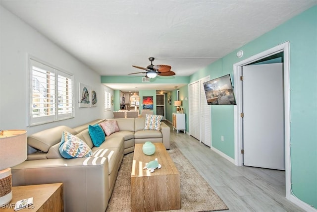 living room with light wood-type flooring and ceiling fan