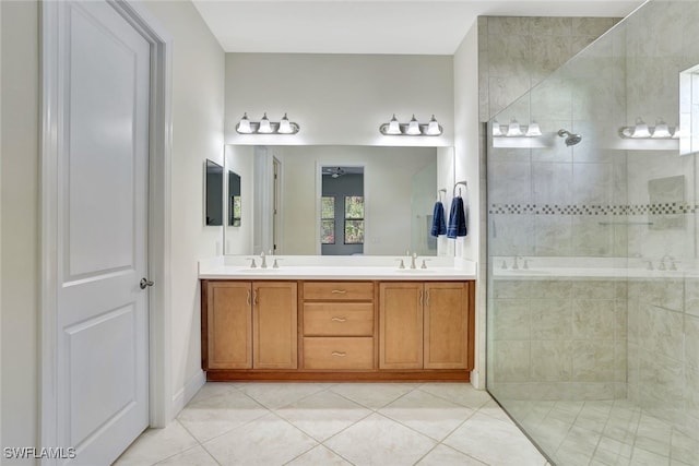 bathroom with tile patterned flooring, vanity, ceiling fan, and tiled shower