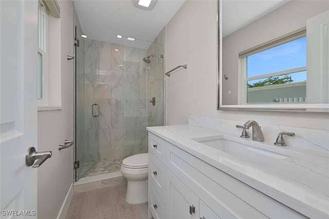 bathroom featuring wood-type flooring, vanity, toilet, and walk in shower