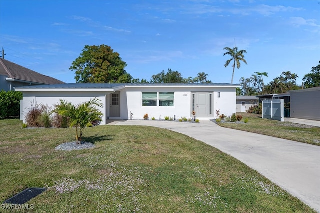 view of front facade with stucco siding and a front yard