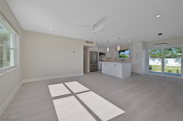 unfurnished living room with light wood-type flooring and ceiling fan