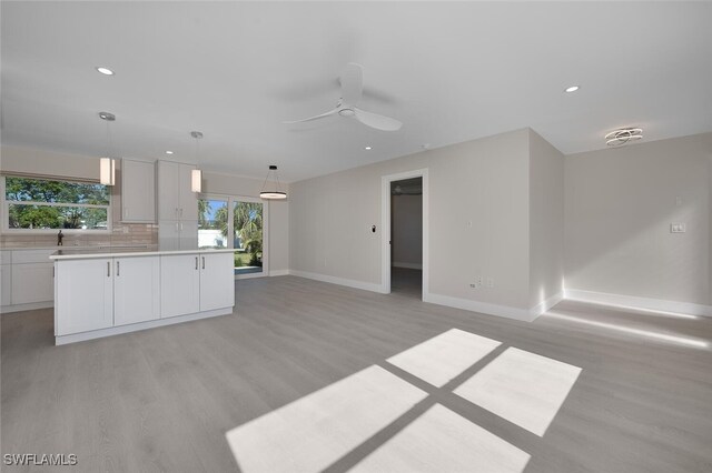 interior space featuring light countertops, light wood-style flooring, recessed lighting, and baseboards