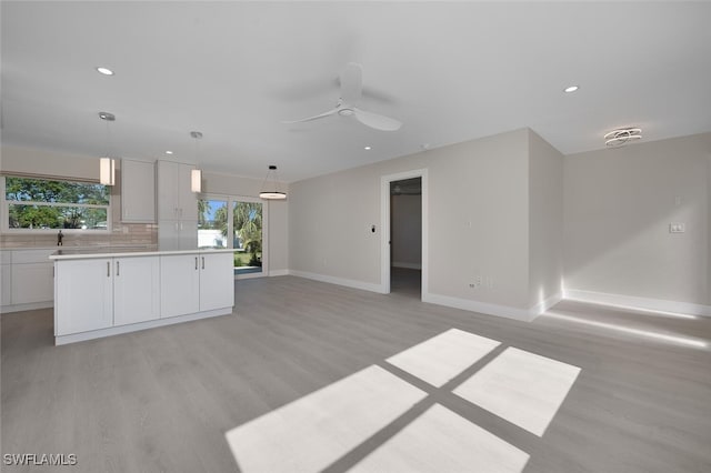unfurnished living room featuring recessed lighting, baseboards, ceiling fan, and light wood-style floors