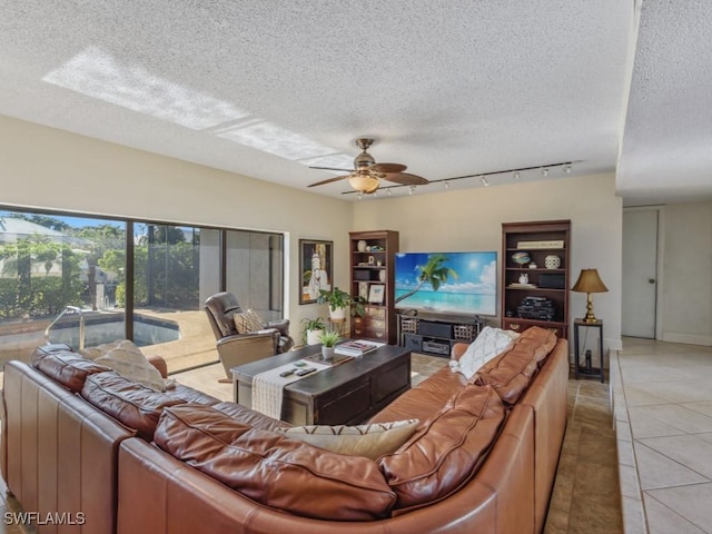 living room featuring ceiling fan, light tile patterned floors, and a textured ceiling