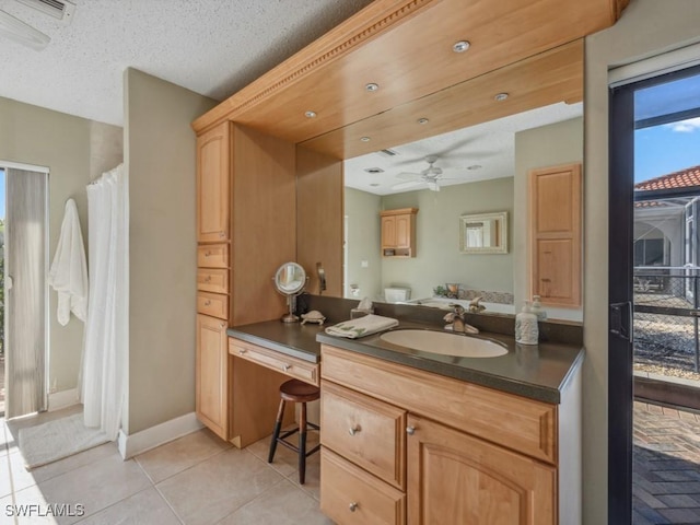 bathroom with ceiling fan, tile patterned flooring, vanity, and a textured ceiling