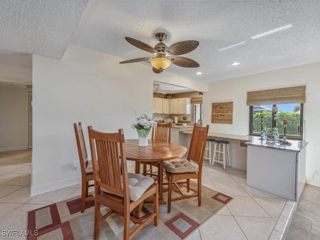 dining room featuring ceiling fan, light tile patterned floors, and a textured ceiling