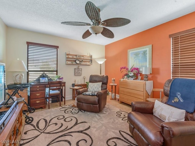 living area featuring a textured ceiling and ceiling fan