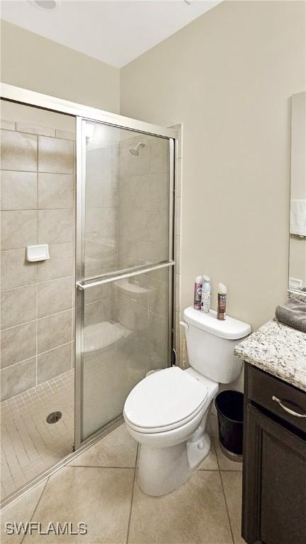 full bathroom with tile patterned flooring, vanity, and a shower stall