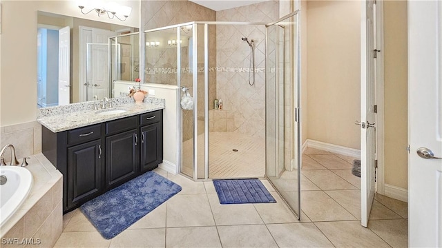 bathroom with a stall shower, tile patterned flooring, a garden tub, and vanity