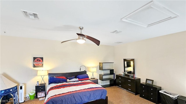 bedroom with attic access, light colored carpet, visible vents, and ceiling fan