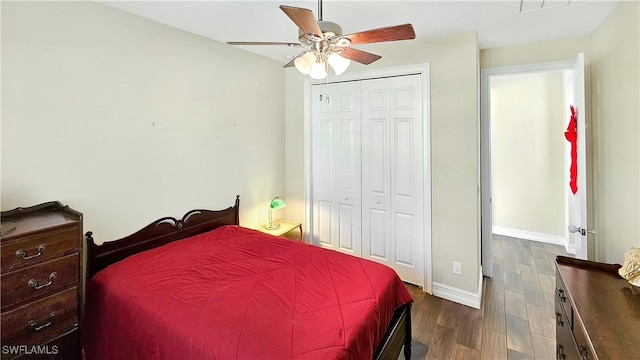 bedroom featuring dark wood-style floors, a closet, visible vents, a ceiling fan, and baseboards