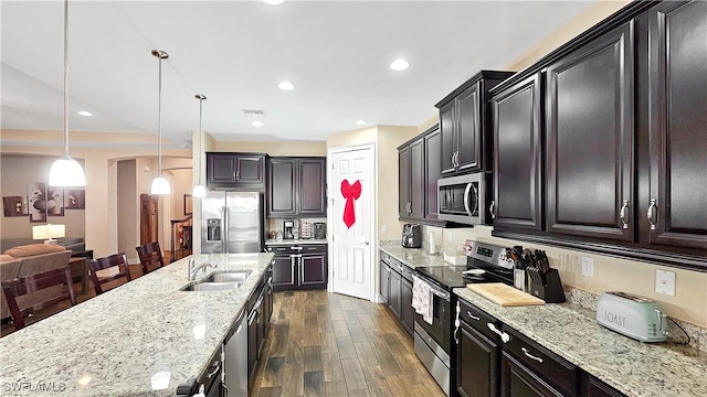 3240 Banyon Hollow Loop, North Fort Myers, FL 33903 - kitchen with stainless steel appliances, a sink, dark wood finished floors, light stone counters, and decorative light fixtures