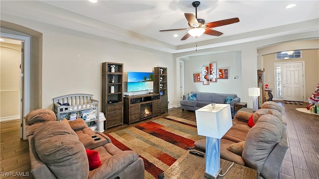 living area featuring baseboards, wood finished floors, a ceiling fan, and recessed lighting