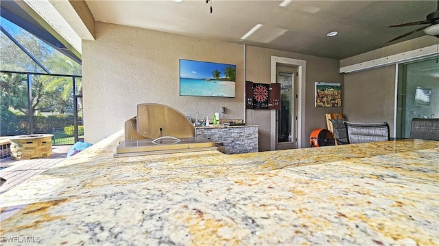 kitchen with ceiling fan and a textured wall