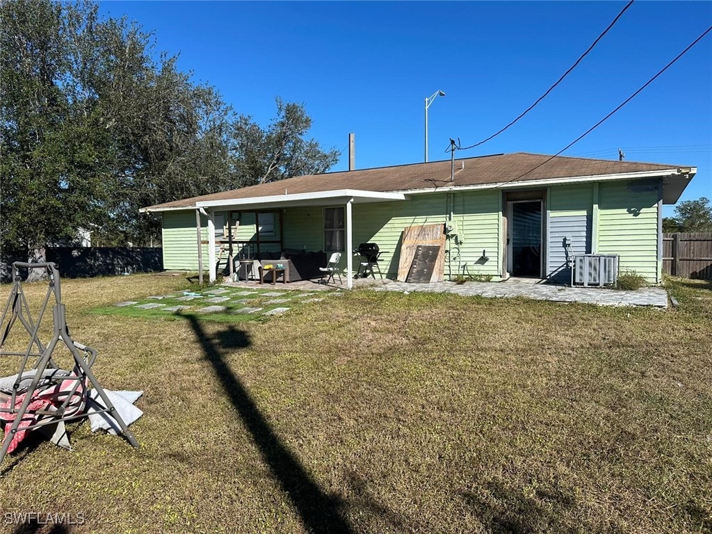 back of property featuring a lawn