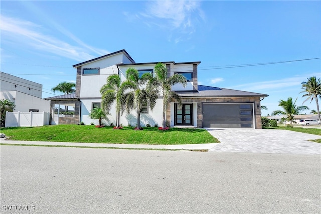 modern home with metal roof, a garage, fence, decorative driveway, and a standing seam roof