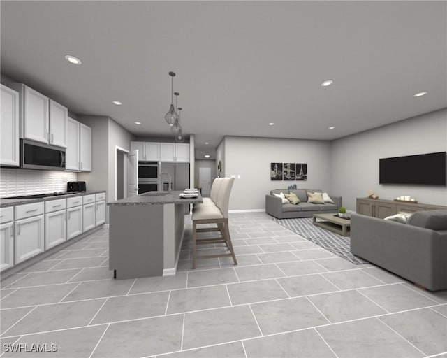 kitchen with white cabinets, decorative backsplash, stainless steel appliances, and an island with sink