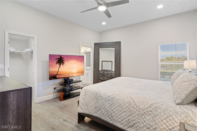 bedroom featuring a walk in closet, ceiling fan, a closet, and light hardwood / wood-style floors