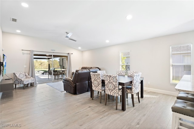 dining room with ceiling fan, lofted ceiling, and light hardwood / wood-style flooring