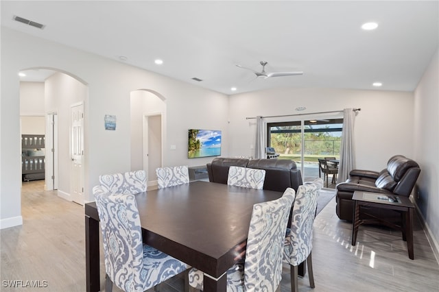 dining space featuring light wood-type flooring, vaulted ceiling, and ceiling fan