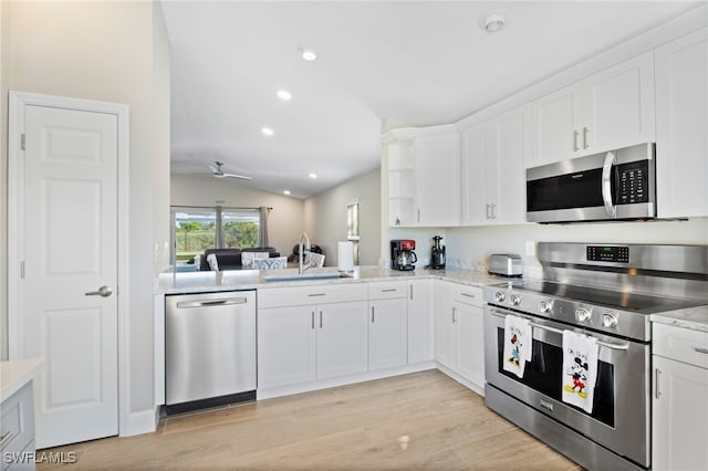 kitchen featuring white cabinets, lofted ceiling, sink, and appliances with stainless steel finishes