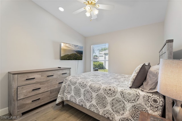 bedroom featuring light hardwood / wood-style floors, vaulted ceiling, and ceiling fan