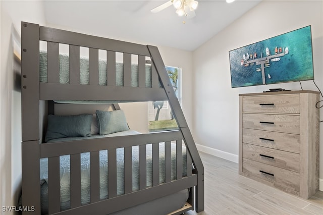 bedroom with ceiling fan, wood-type flooring, and lofted ceiling