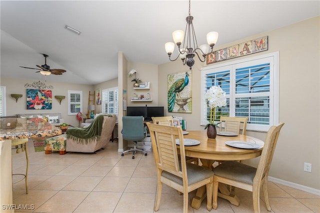 tiled dining area featuring ceiling fan with notable chandelier and vaulted ceiling