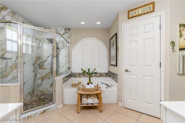 bathroom with tile patterned flooring, vanity, and plus walk in shower