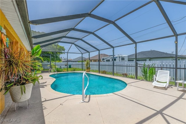 view of pool with glass enclosure and a patio area