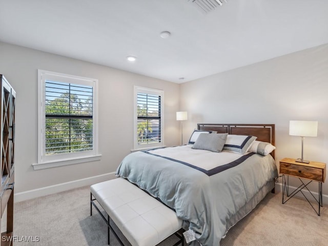 bedroom featuring baseboards, visible vents, and light colored carpet