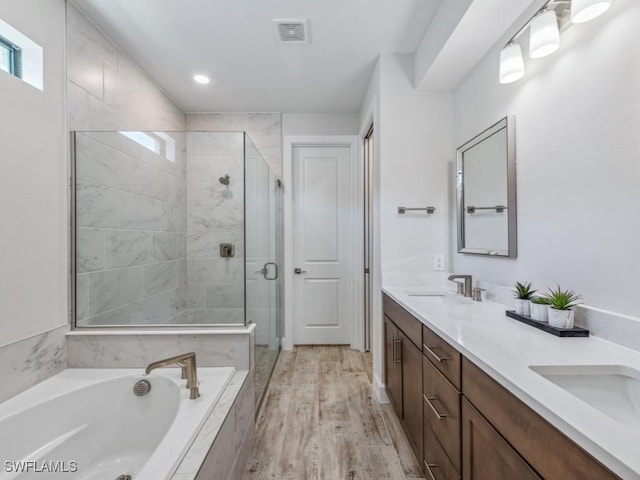 bathroom with double vanity, visible vents, a sink, a shower stall, and a bath