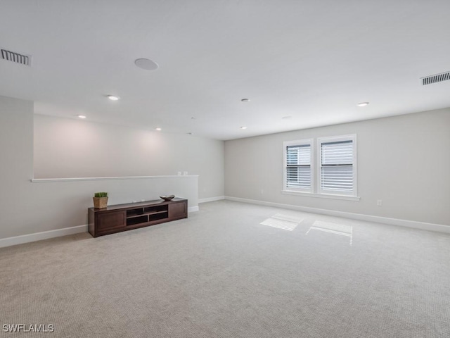 unfurnished room featuring baseboards, visible vents, and light colored carpet