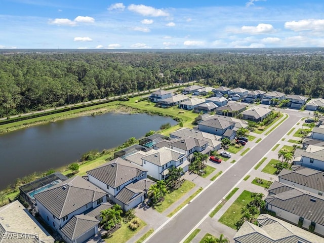 drone / aerial view with a forest view, a water view, and a residential view