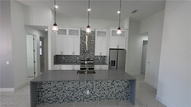 kitchen featuring a center island with sink, pendant lighting, white cabinetry, and appliances with stainless steel finishes