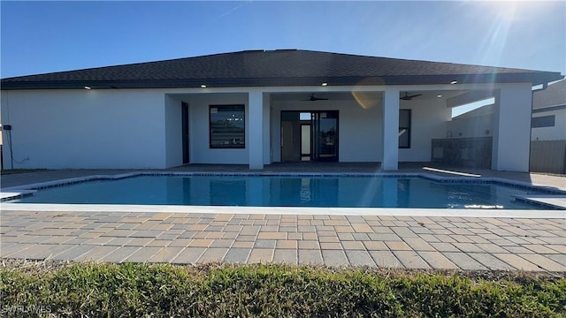 view of swimming pool featuring ceiling fan, a patio, and an outdoor kitchen