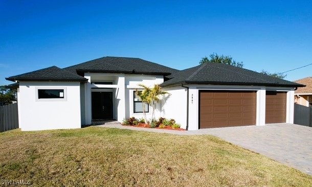 view of front of home with a front yard and a garage