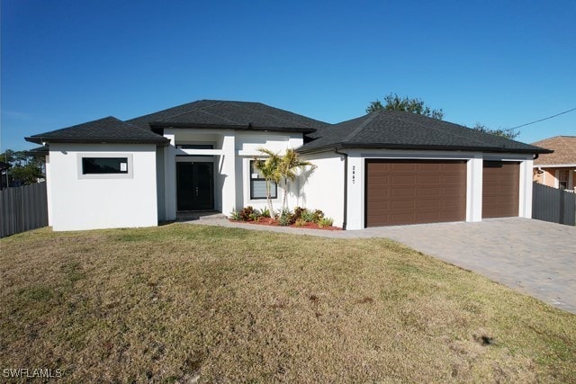 prairie-style home featuring a garage and a front lawn