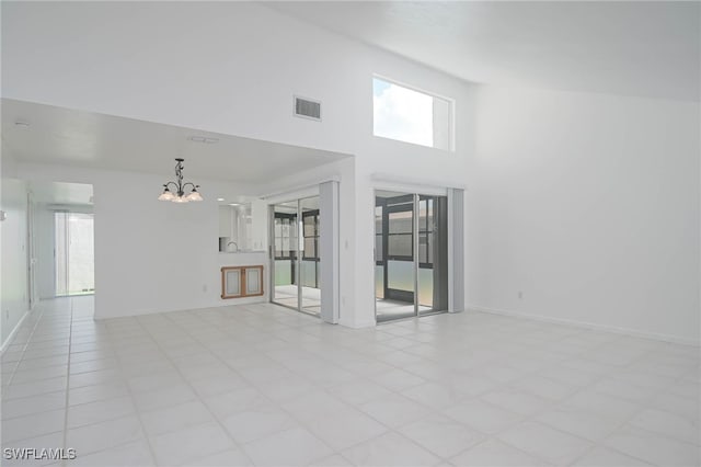 unfurnished room with a high ceiling and an inviting chandelier