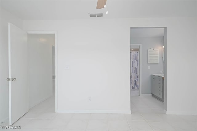 unfurnished bedroom with ensuite bath, ceiling fan, and light tile patterned flooring