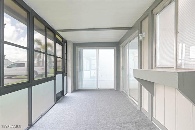 unfurnished sunroom with beam ceiling