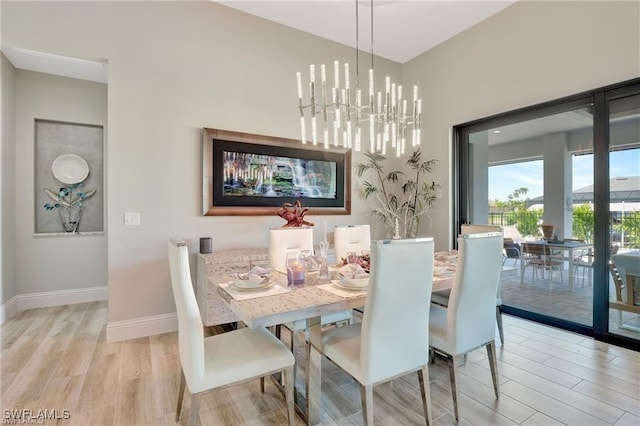 dining space featuring a notable chandelier and light wood-type flooring