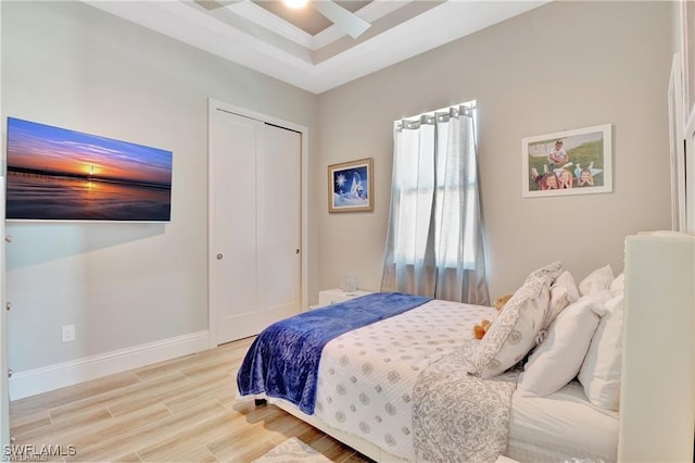 bedroom featuring ceiling fan, a closet, and light hardwood / wood-style flooring