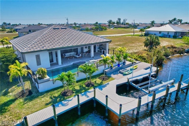 rear view of house with a yard, an outdoor hangout area, a water view, and a patio area