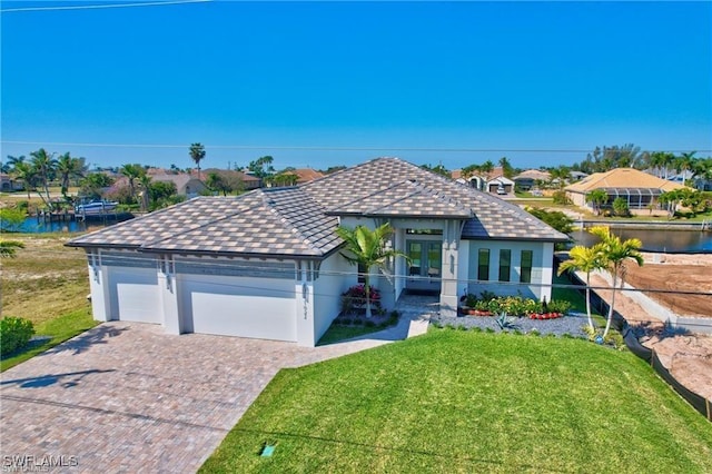 view of front of house with a front lawn, a garage, a water view, and french doors