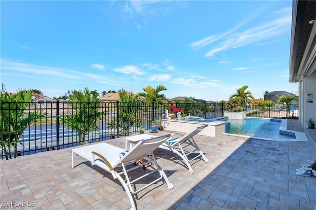 view of patio / terrace featuring pool water feature and a swimming pool with hot tub