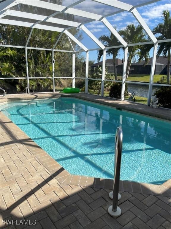 view of swimming pool featuring glass enclosure and a patio