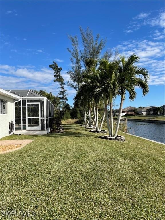 view of yard featuring glass enclosure and a water view