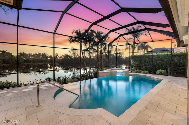 pool at dusk featuring an in ground hot tub, a patio, a water view, and glass enclosure